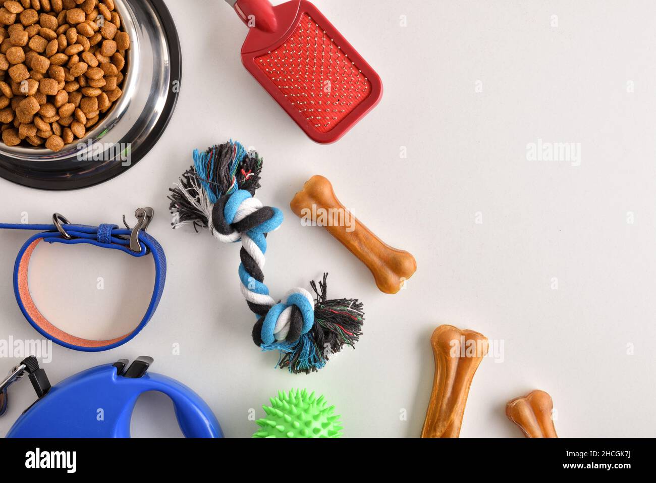 Food and accessories for walk, play and body care for the dog on white table. Top view. Horizontal composition. Stock Photo