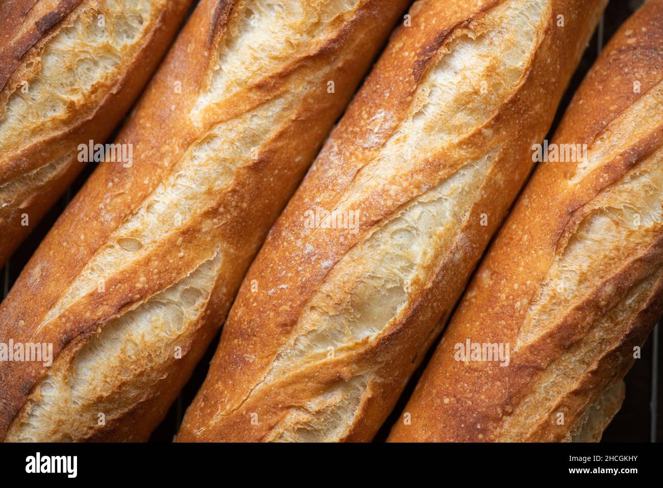 Batch of freshly baked baguettes background. Close up. Stock Photo