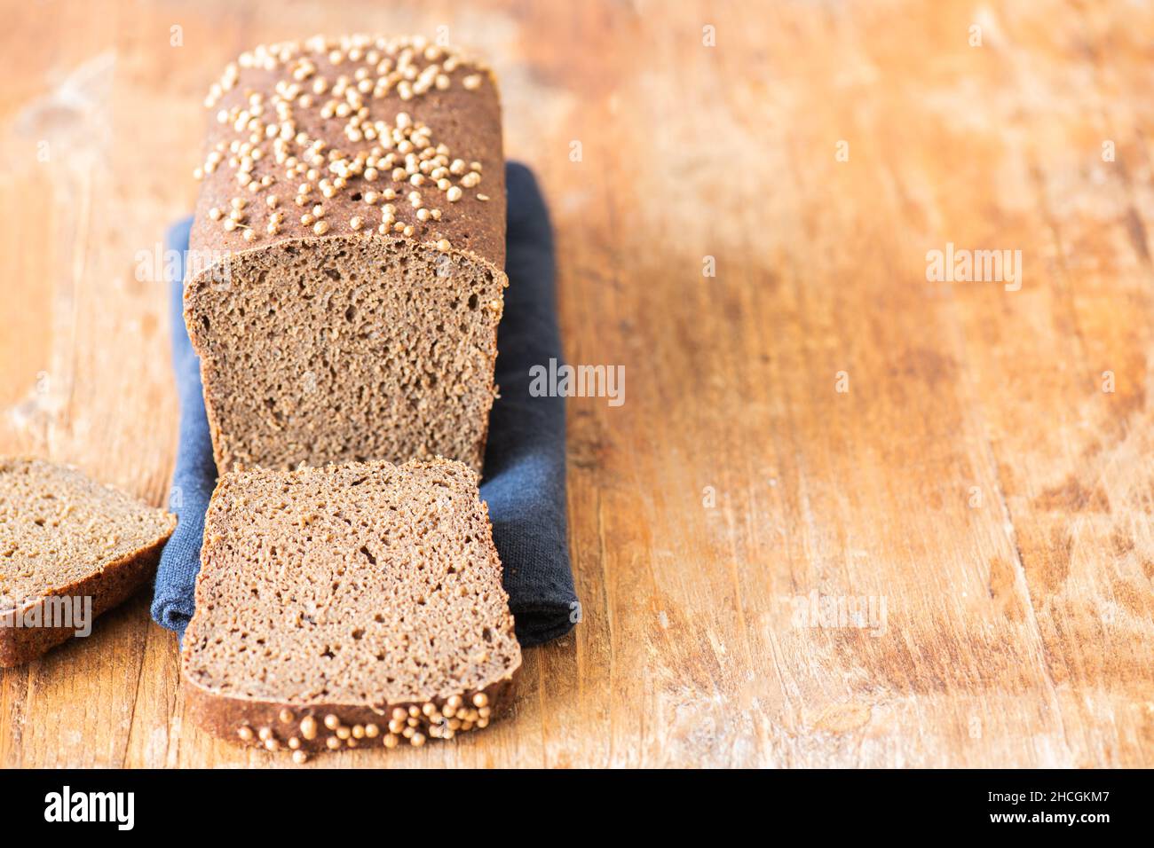 Famous russian rye sourdough bread - Borodinskiy with cardamom and malt on a wooden background, cutted. Close up. Stock Photo