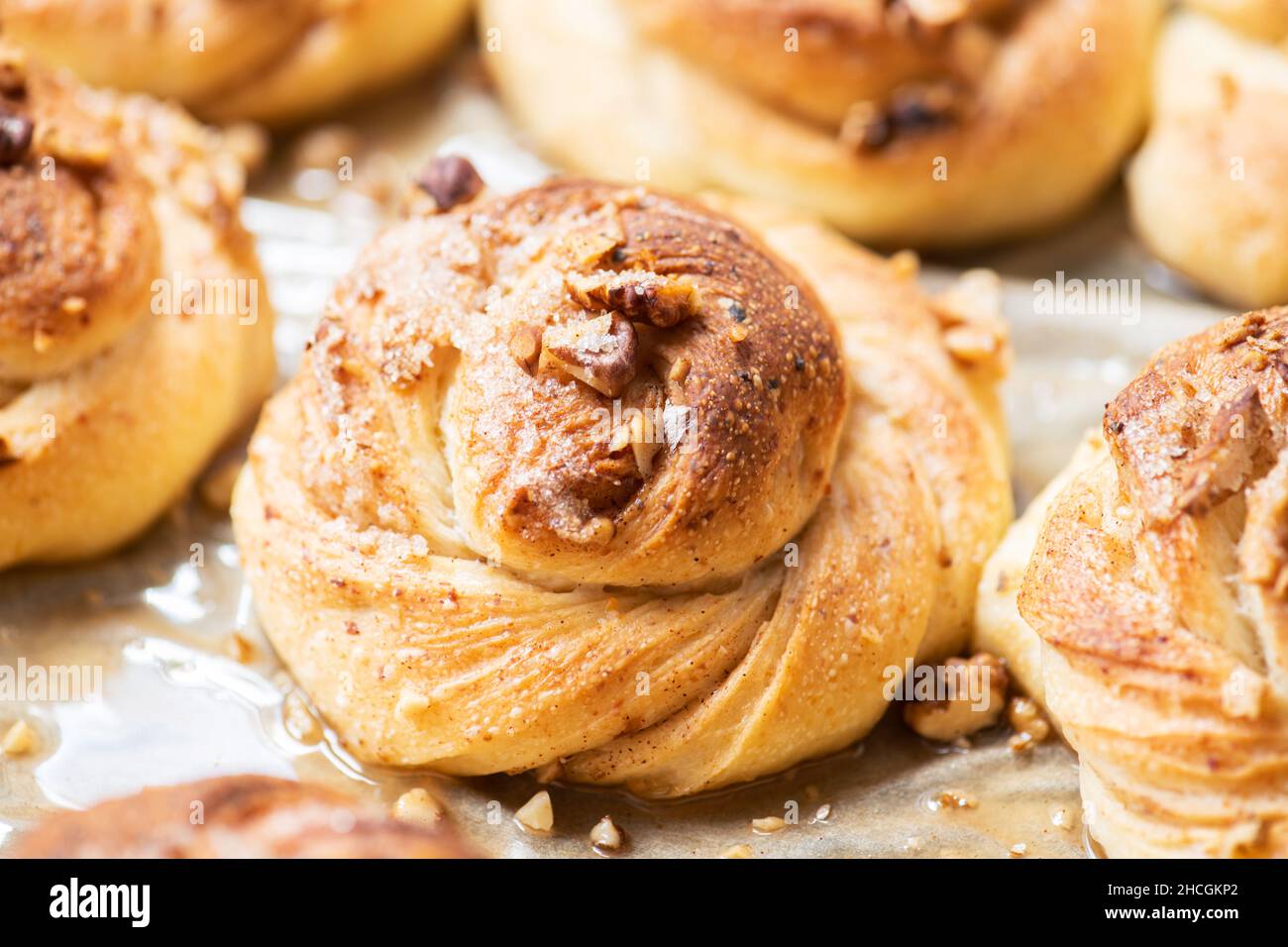 Freshly baked nuts and cardamom sweet buns. Yeasted pastry and cozy baking. Close up. Stock Photo