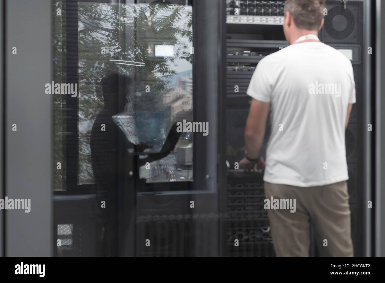 Technicians team updating hardware inspecting system performance in super computer server room or cryptocurrency mining farm. Stock Photo
