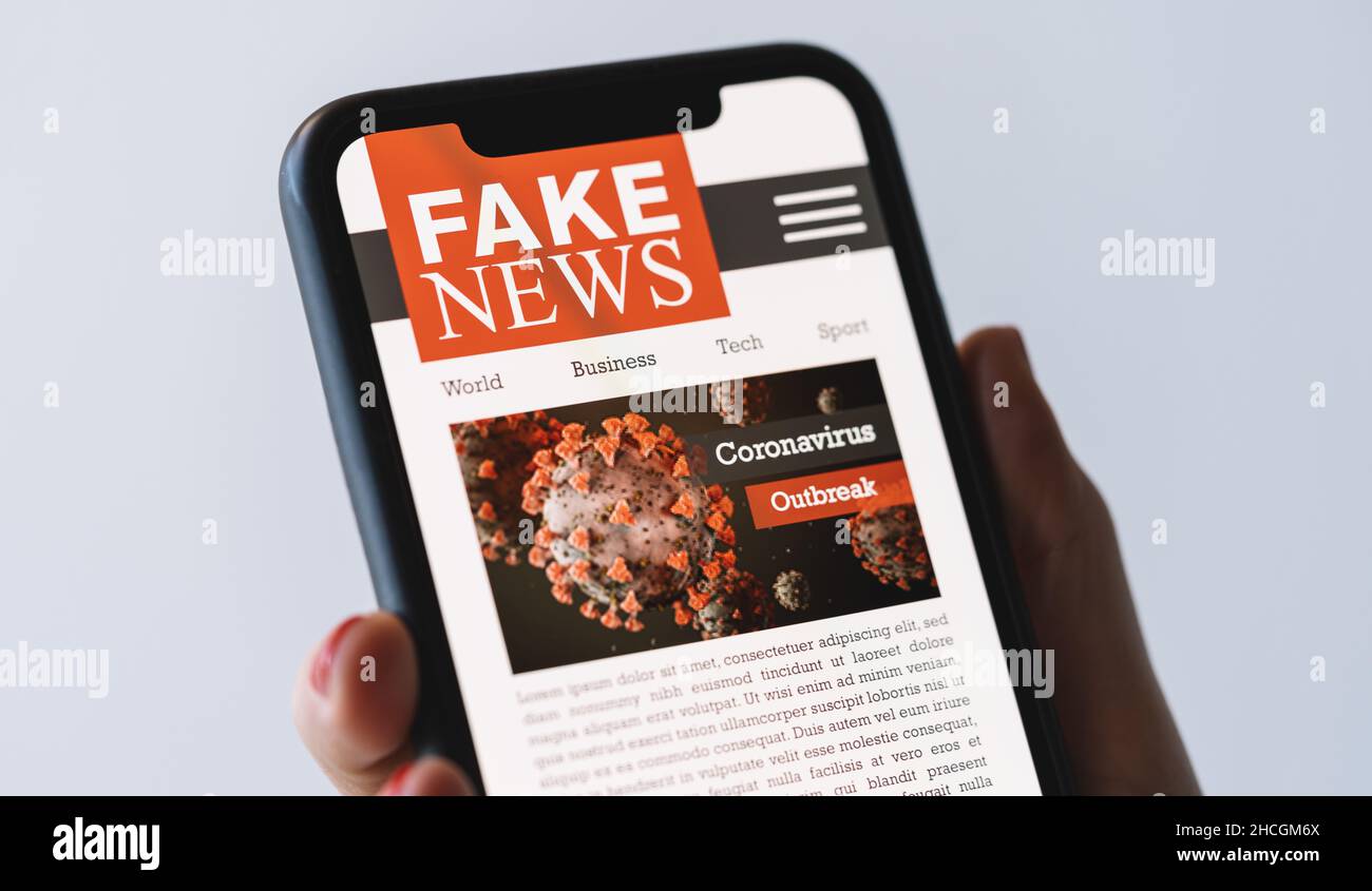 Online Corona Fake news on a mobile phone. Close up of woman reading Fake news or articles about covid-19 in a smartphone screen application. Hand hol Stock Photo