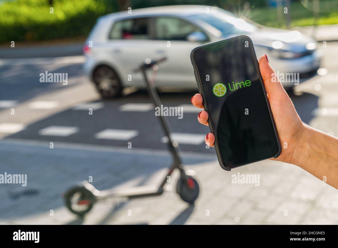 Woman hand holding iphone Xs with logo of CIRC app displayed on a smartphone to rent a e-Scooter. Circ is a rental electric scooter company. Quick and Stock Photo