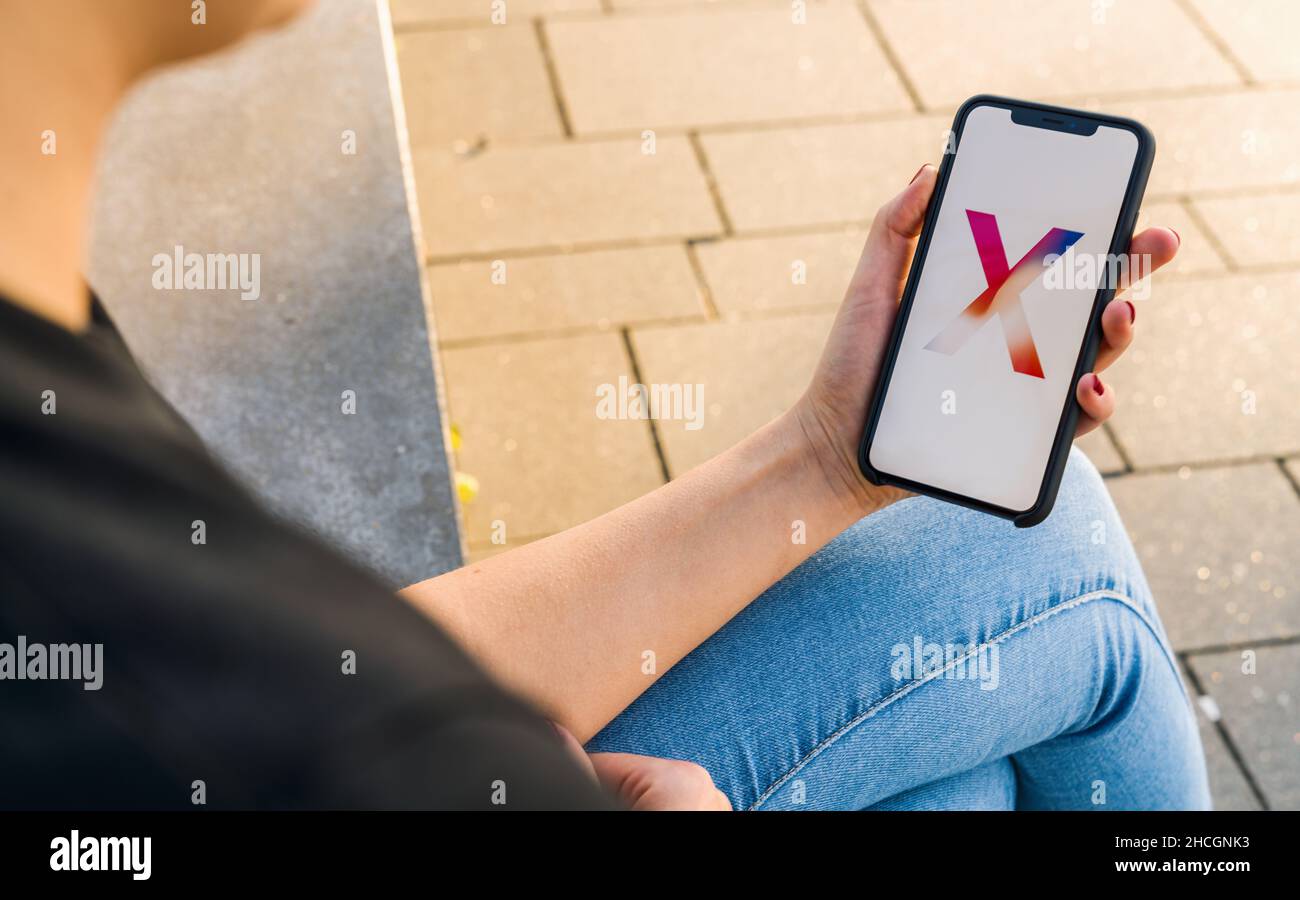 Woman hand holding iphone Xs with logo of the New Apple iPhone X smartphone. Stock Photo