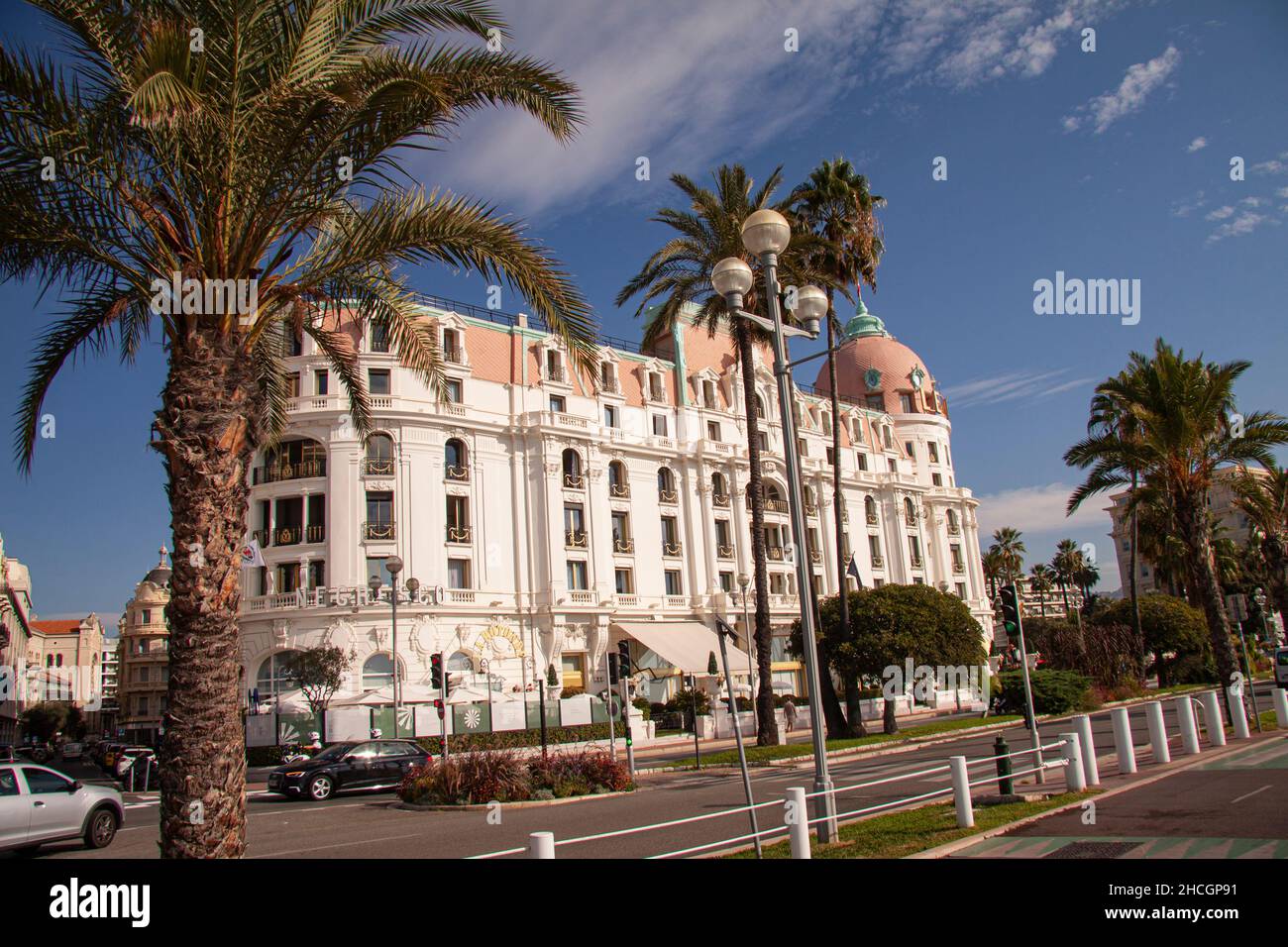 The Negresco Hotel in Nice by the Promenade des Anglais with blue sky at the Mediterranean coast with palm trees in the forground. Nice, France - Sept Stock Photo