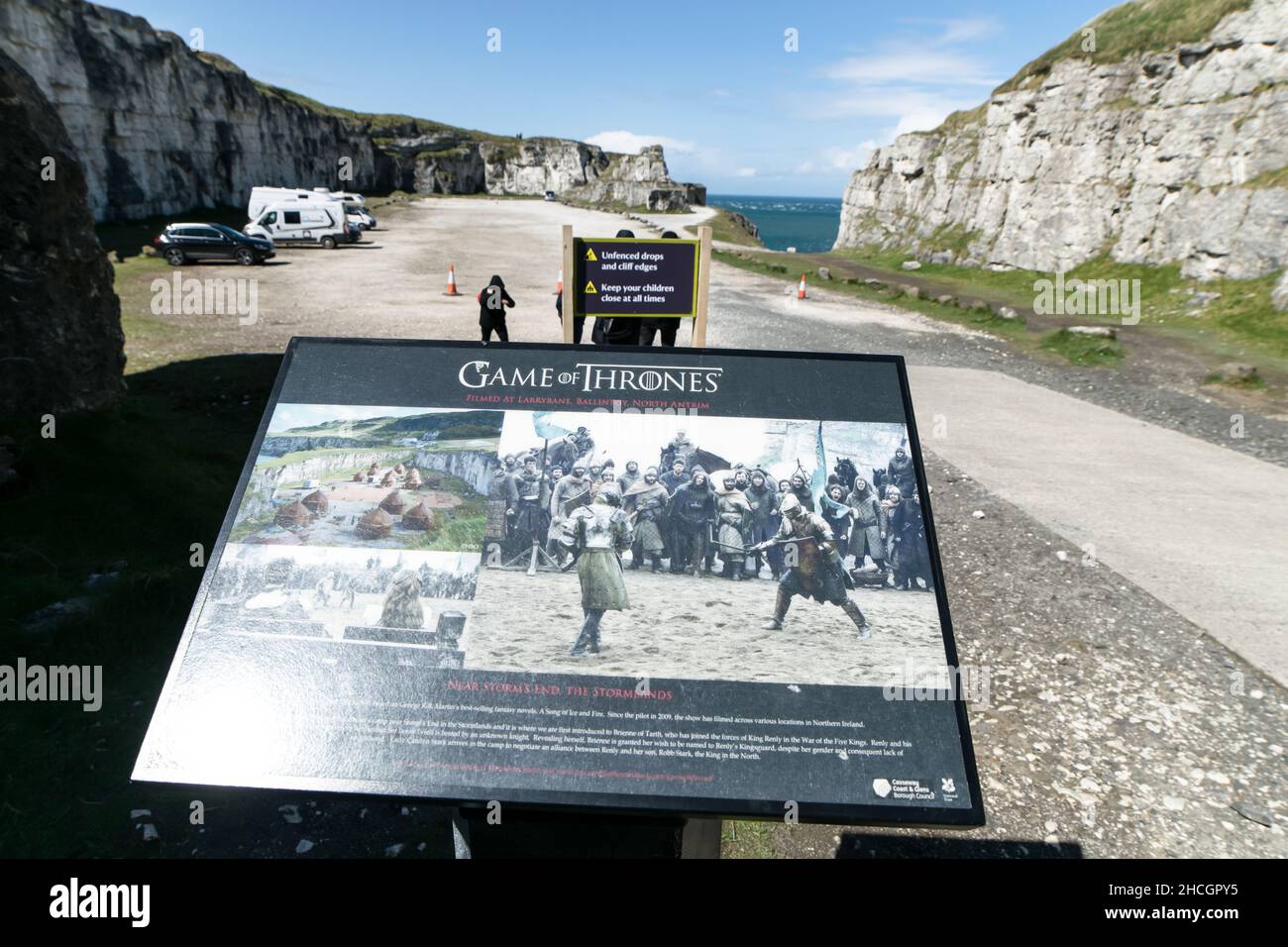 Descriptive board of filming set details and photos and tourists walking on the backround. Game of thrones filming sites Ballintoy. Northern Ireland.U Stock Photo
