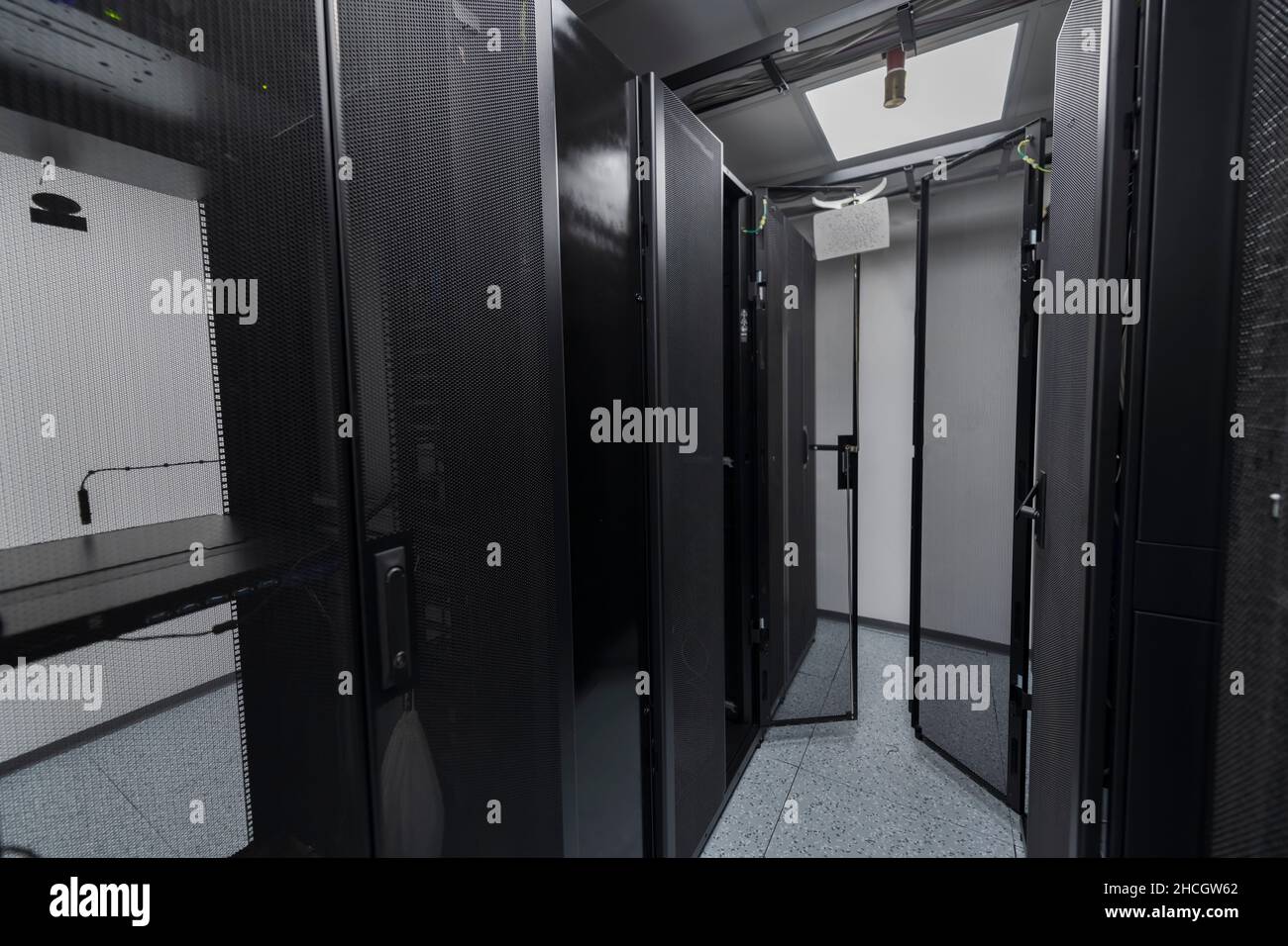 Data Center With Multiple Rows of Fully Operational Server Racks. Modern Telecommunications, Cloud Computing, Artificial Intelligence, Database Stock Photo
