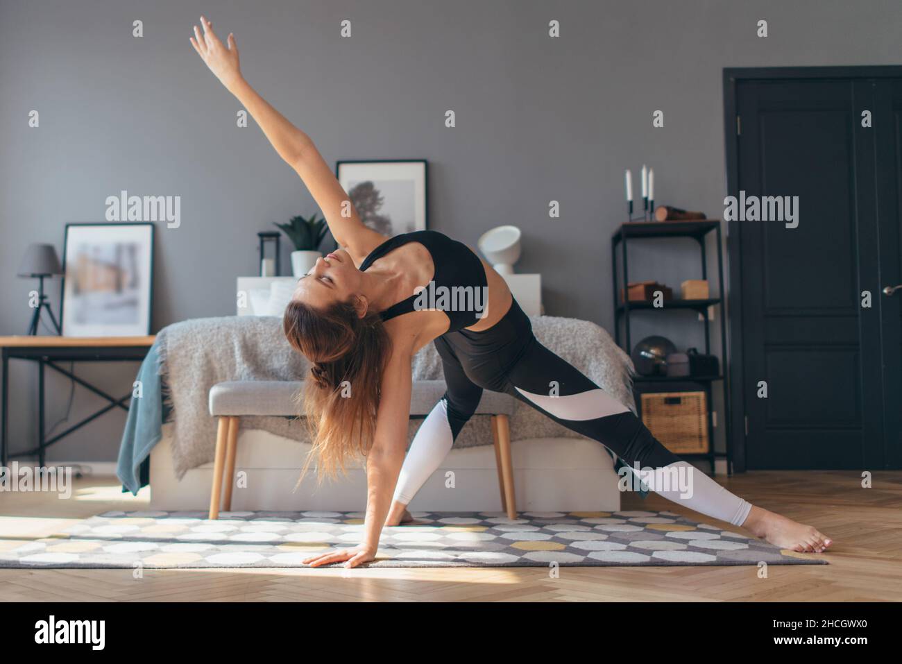 Fit woman trains at home, doing backbend Stock Photo - Alamy
