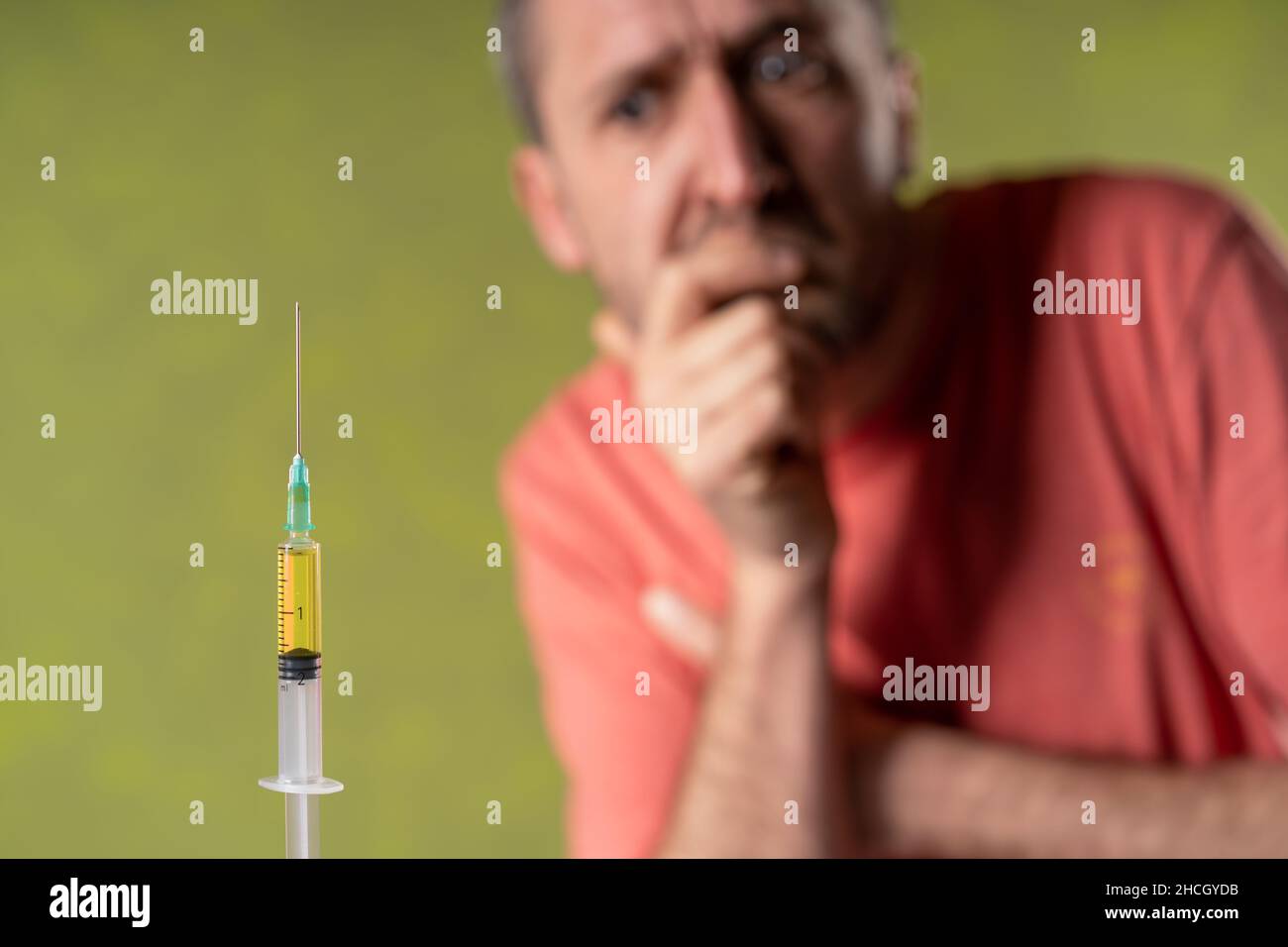Suspicious man looks doubtfully  the anti covid vaccine. Stock Photo