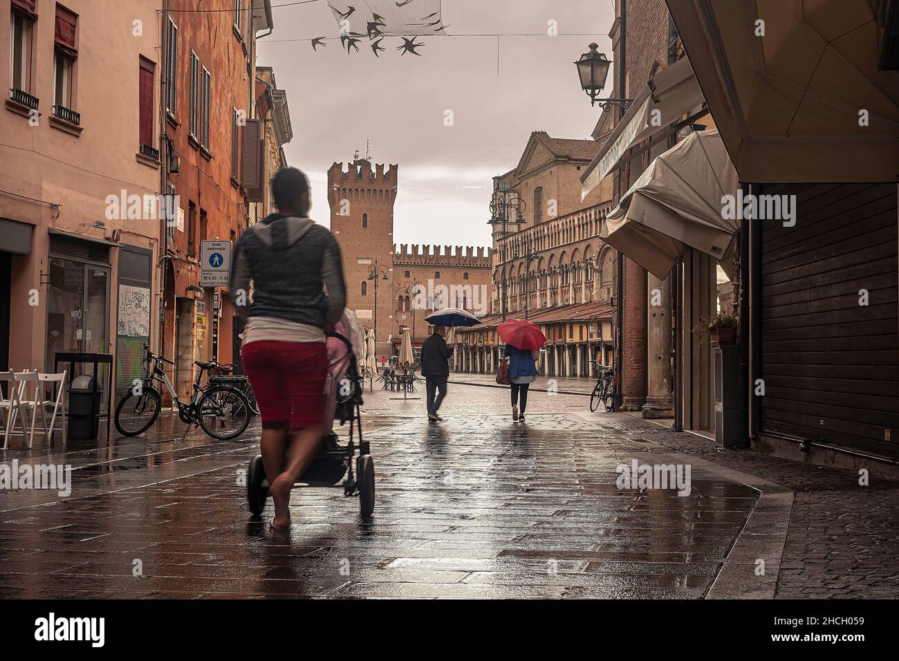 FERRARA, ITALY 29 JULY 2020 : Evocative view of the street that leads to Piazza Trento Trieste in Ferrara in Italy with people in their daily lives Stock Photo