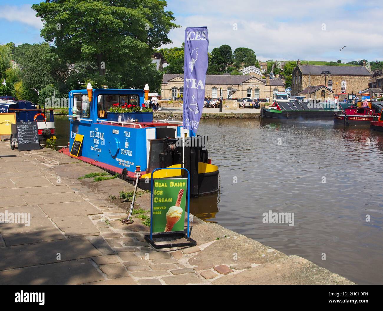 The ice cream boat moored in the sunshine at the canal basin on the Leeds and Liverpool canal in Skipton, North Yorkshire, England. Stock Photo