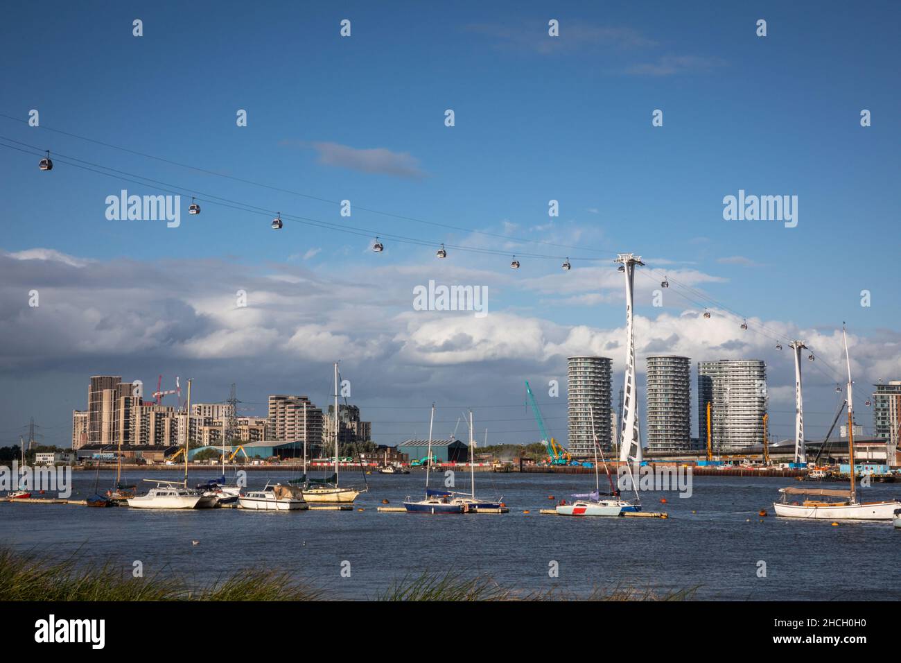 The Emirates Air Line cable car stretches across the Thames against a backdrop of new apartment blocks in East London, England, UK Stock Photo