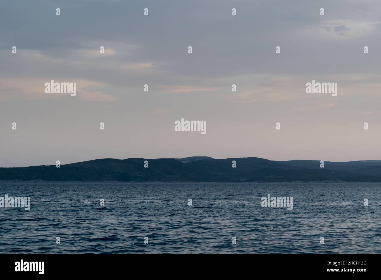 Seascape with wavy Adriatic sea and Brac island silhouette in Croatia at dusk Stock Photo