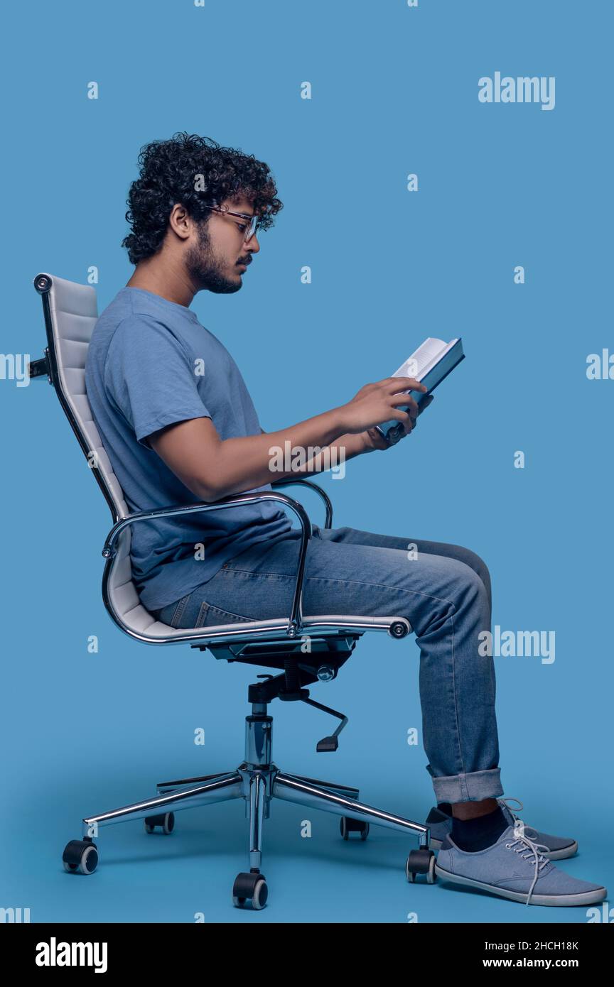 Concentrated guy in eyeglasses perusing his diary entries Stock Photo