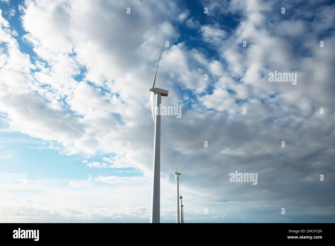 Wind turbines against blue sky with clouds Stock Photo - Alamy