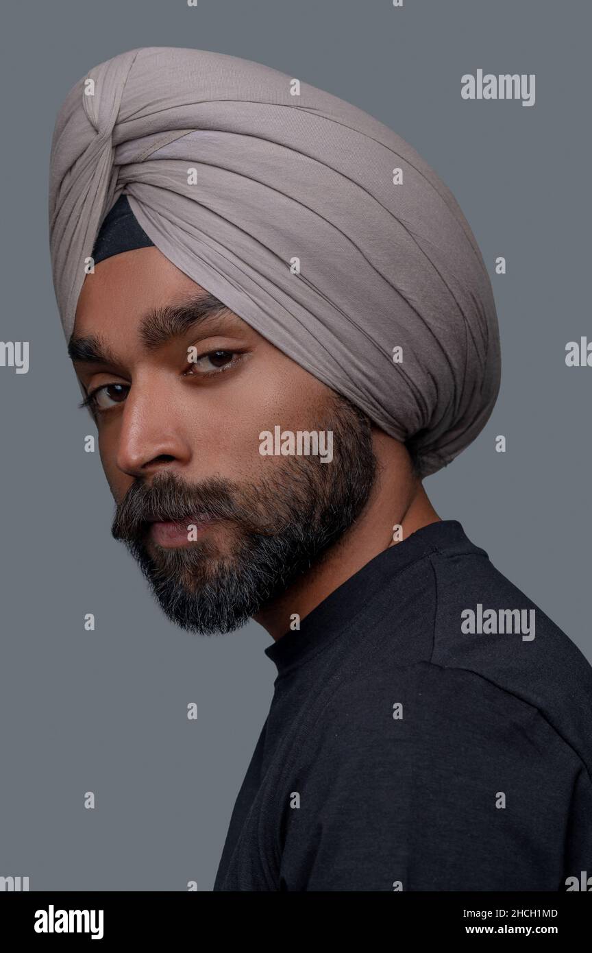 Calm bearded mustached man in the head wrap staring ahead Stock Photo