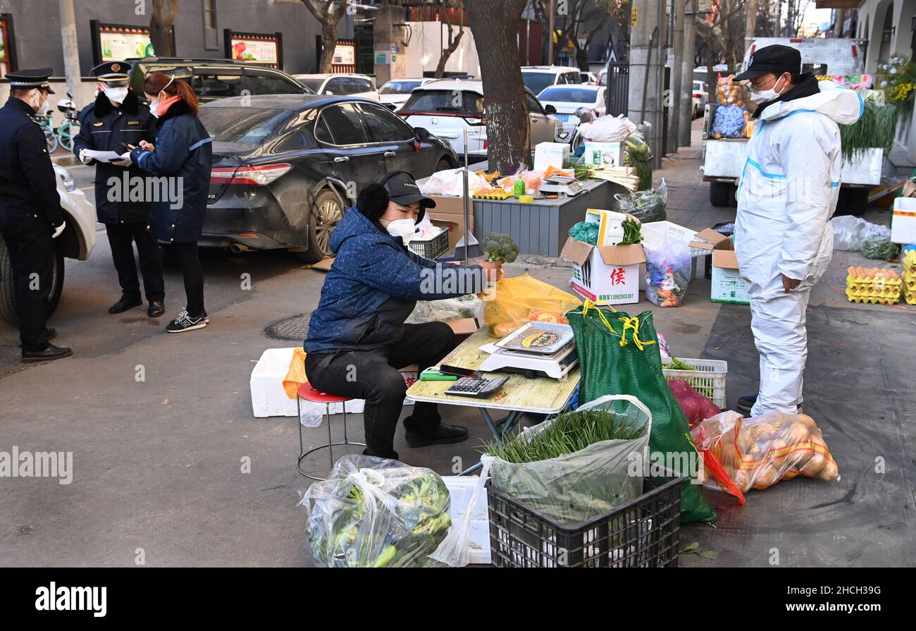 Xi'an, China's Shaanxi Province. 29th Dec, 2021. A temporary vegetable market is set up near a community under closed-off management in Xi'an, capital of northwest China's Shaanxi Province, Dec. 29, 2021. Authorities in Xi'an have upgraded epidemic control and prevention measures starting Monday, ordering all residents to stay indoors and refrain from gatherings except when taking nucleic acid tests. Daily necessities of residents were guaranteed every day through delivery services. Credit: Tao Ming/Xinhua/Alamy Live News Stock Photo