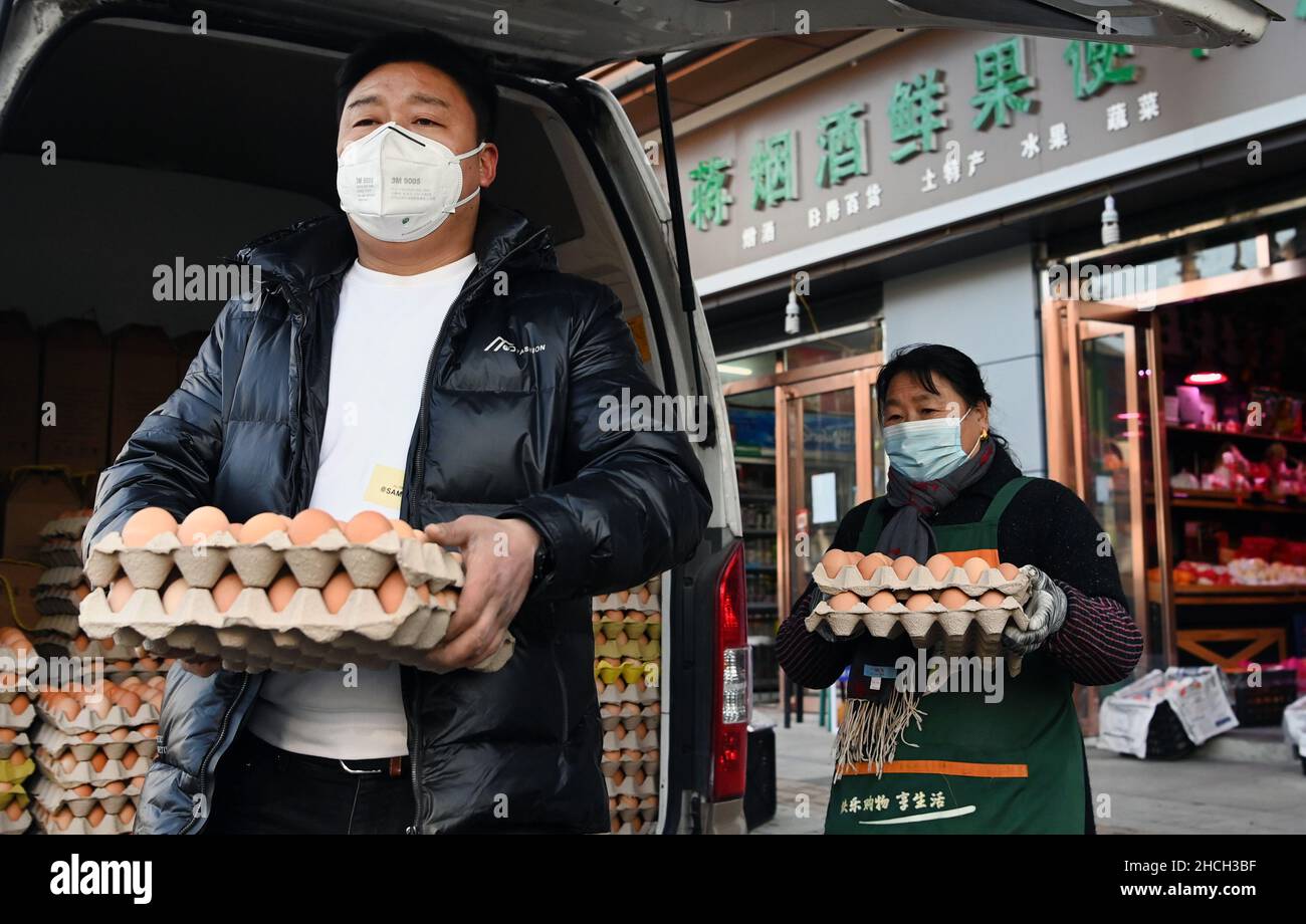 Xi'an, China's Shaanxi Province. 29th Dec, 2021. Supermarket employees deliver eggs to households under closed-off management in Xi'an, capital of northwest China's Shaanxi Province, Dec. 29, 2021. Authorities in Xi'an have upgraded epidemic control and prevention measures starting Monday, ordering all residents to stay indoors and refrain from gatherings except when taking nucleic acid tests. Daily necessities of residents were guaranteed every day through delivery services. Credit: Tao Ming/Xinhua/Alamy Live News Stock Photo