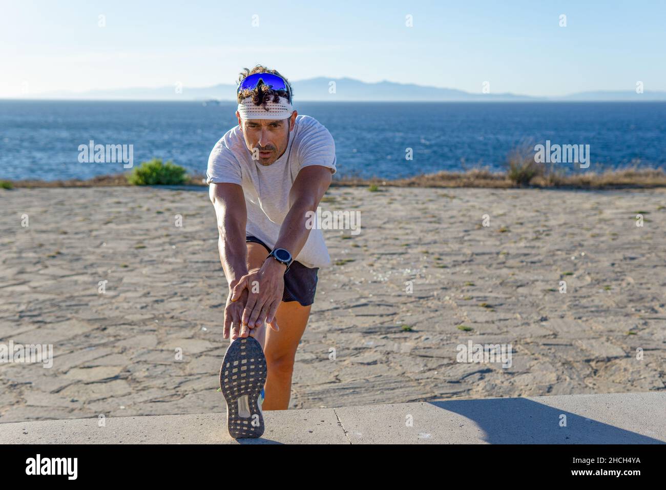 Young man stretching legs in park hi-res stock photography and images ...