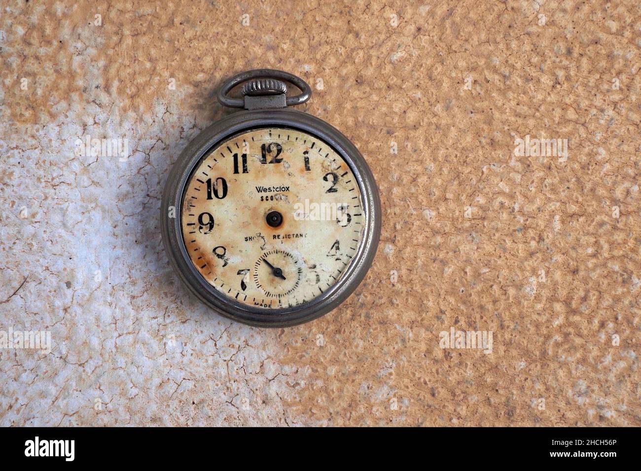 Old pocket watch without hands on stone base with patina, timeless Stock Photo