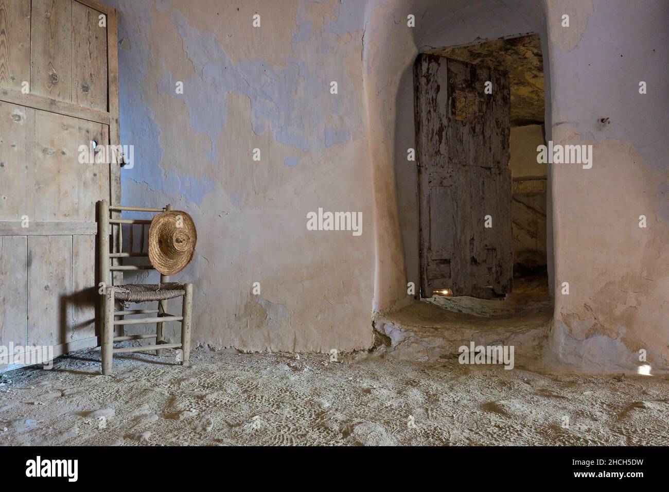 Still life with wooden chair and straw hat, room of a cave house, Andalusia, Spain Stock Photo