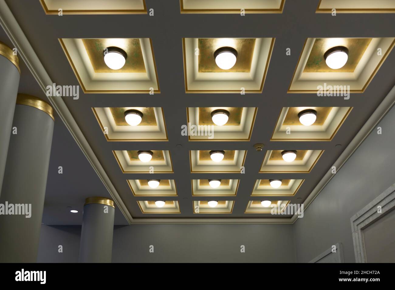 Geometric ceiling with square boxes and round lamps in a row and column