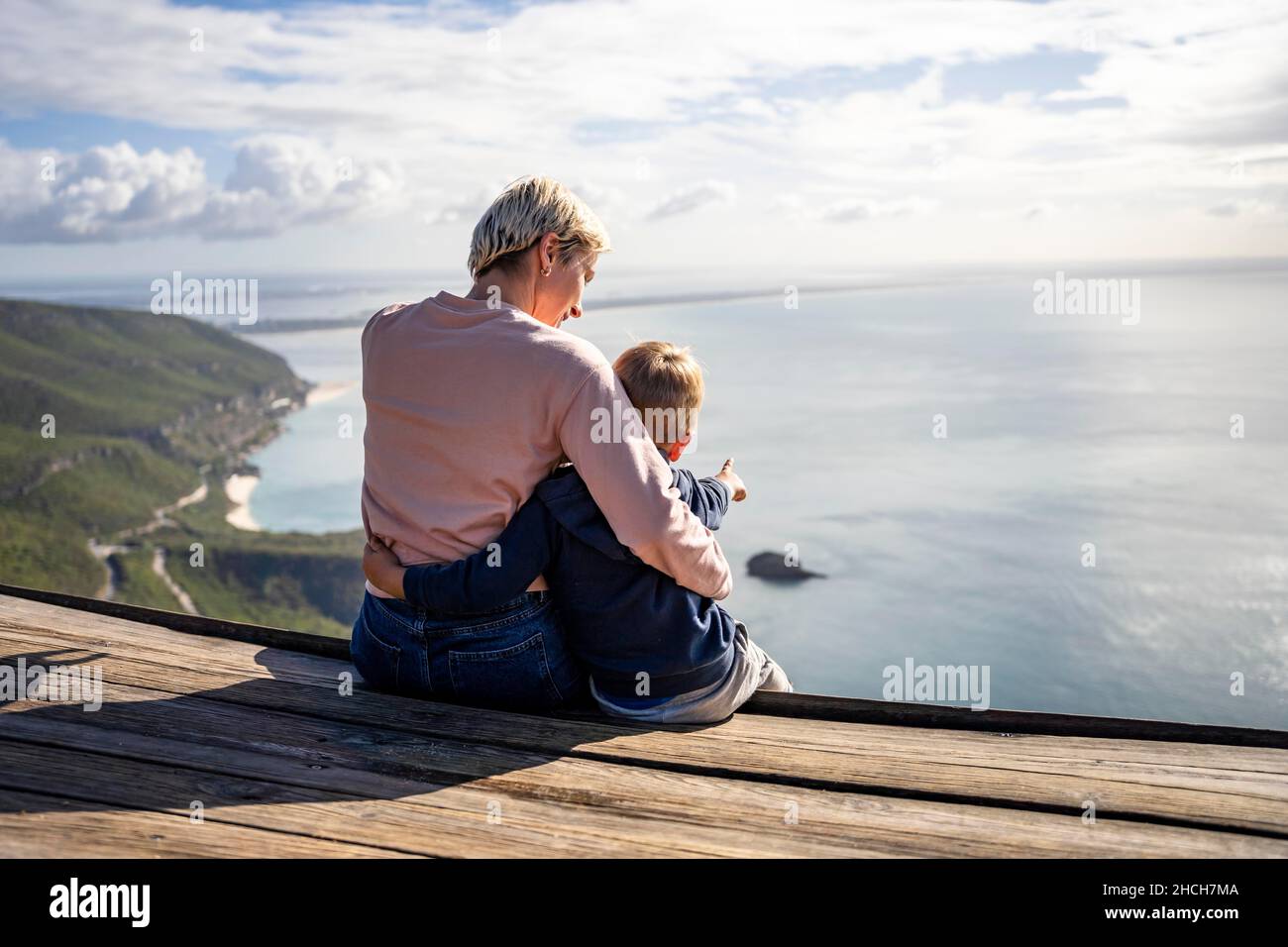 Mother and 3 years old son hugging each other and enjoying the beautiful ocean views, Portugal Stock Photo