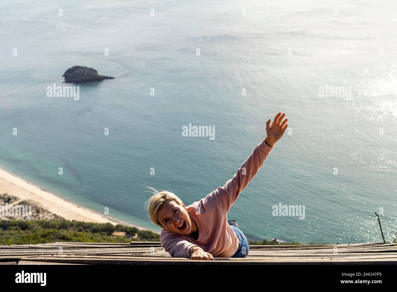 Woman falling from the high into the ocean, Miradouro do Portinho da Arrabida, Portugal Stock Photo