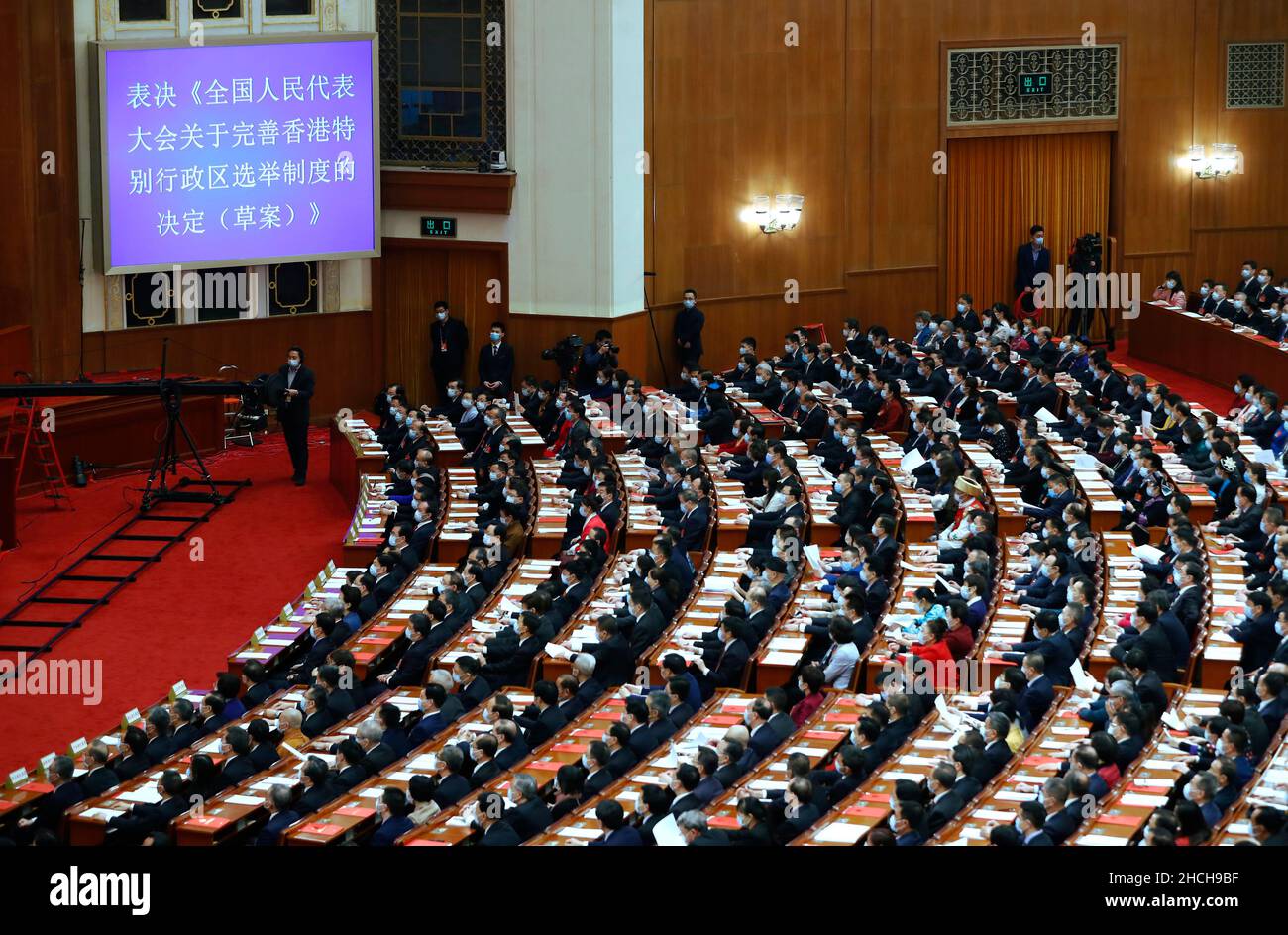 (211229) -- BEIJING, Dec. 29, 2021 (Xinhua) -- Deputies to the 13th National People's Congress (NPC) vote overwhelmingly to approve the NPC Decision on improving the electoral system of the Hong Kong Special Administrative Region (HKSAR) at the closing meeting of the fourth session of the 13th NPC at the Great Hall of the People in Beijing, capital of China, March 11, 2021. Xinhua's top 10 China news events in 2021    3. Hong Kong's electoral system is improved     On March 11, China's top legislature adopted a decision on improving the electoral system of the Hong Kong Special Administrative Stock Photo