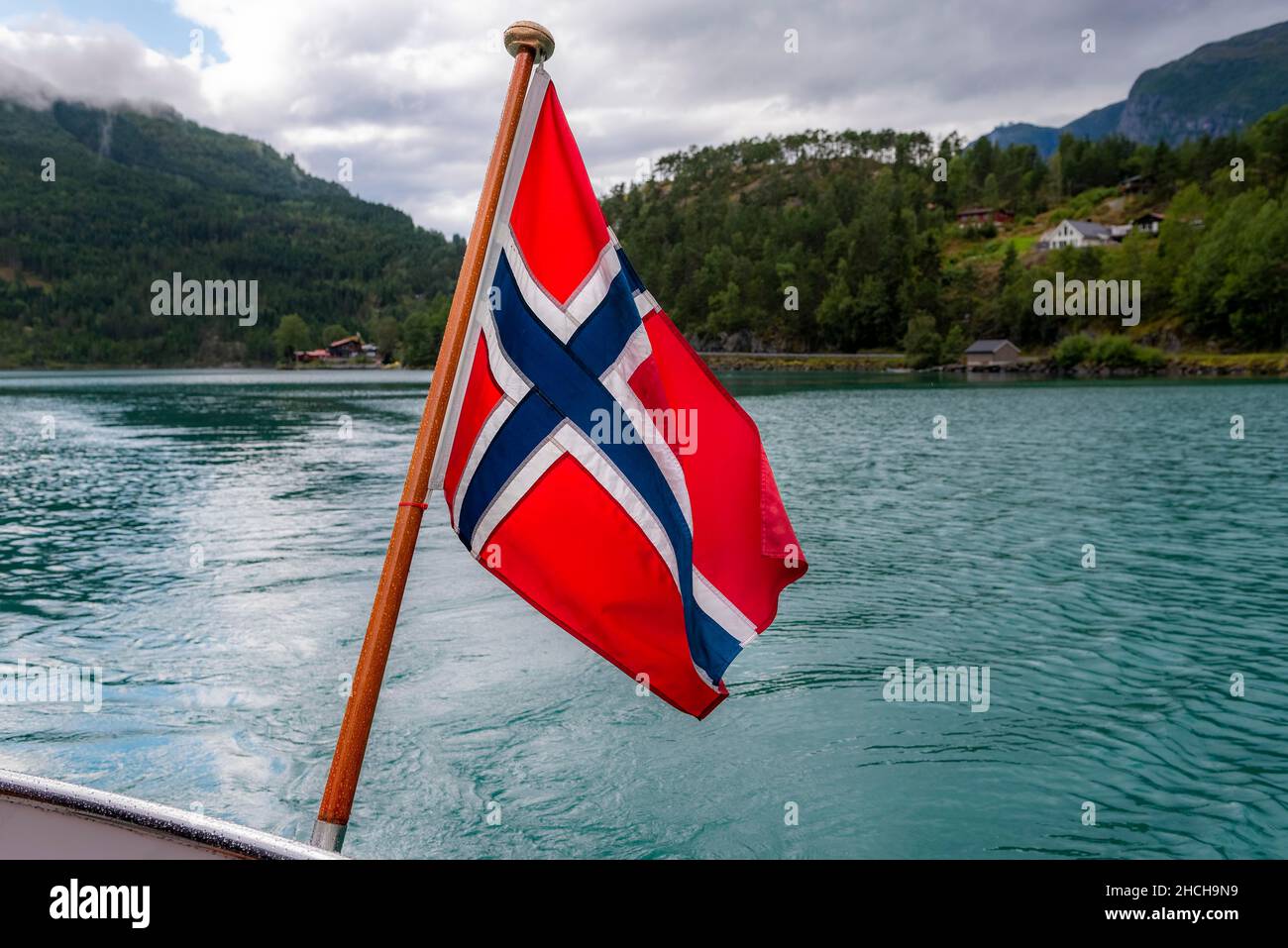 The Norwegian flag flies at the stern of a boat on Lovatnet, Norway ...