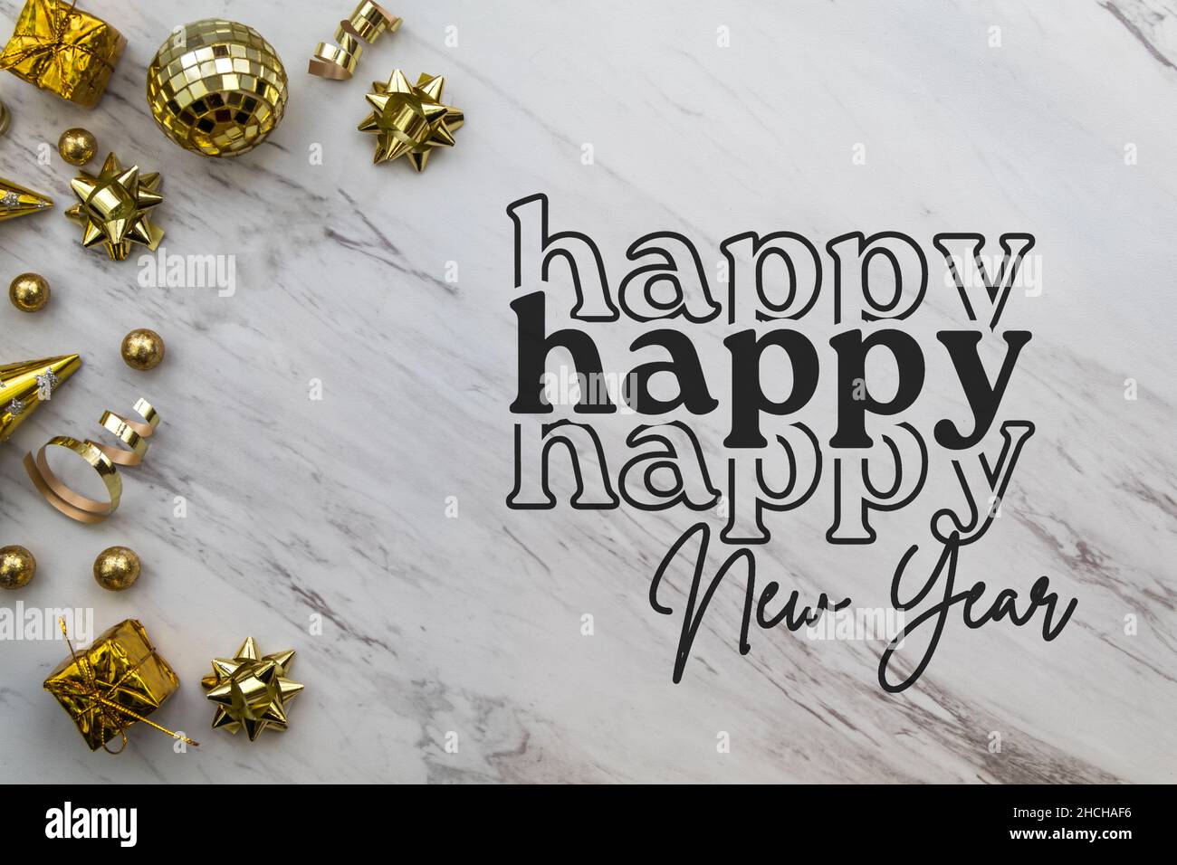 Happy New Year text script with festive gold decorations on white marble background Stock Photo