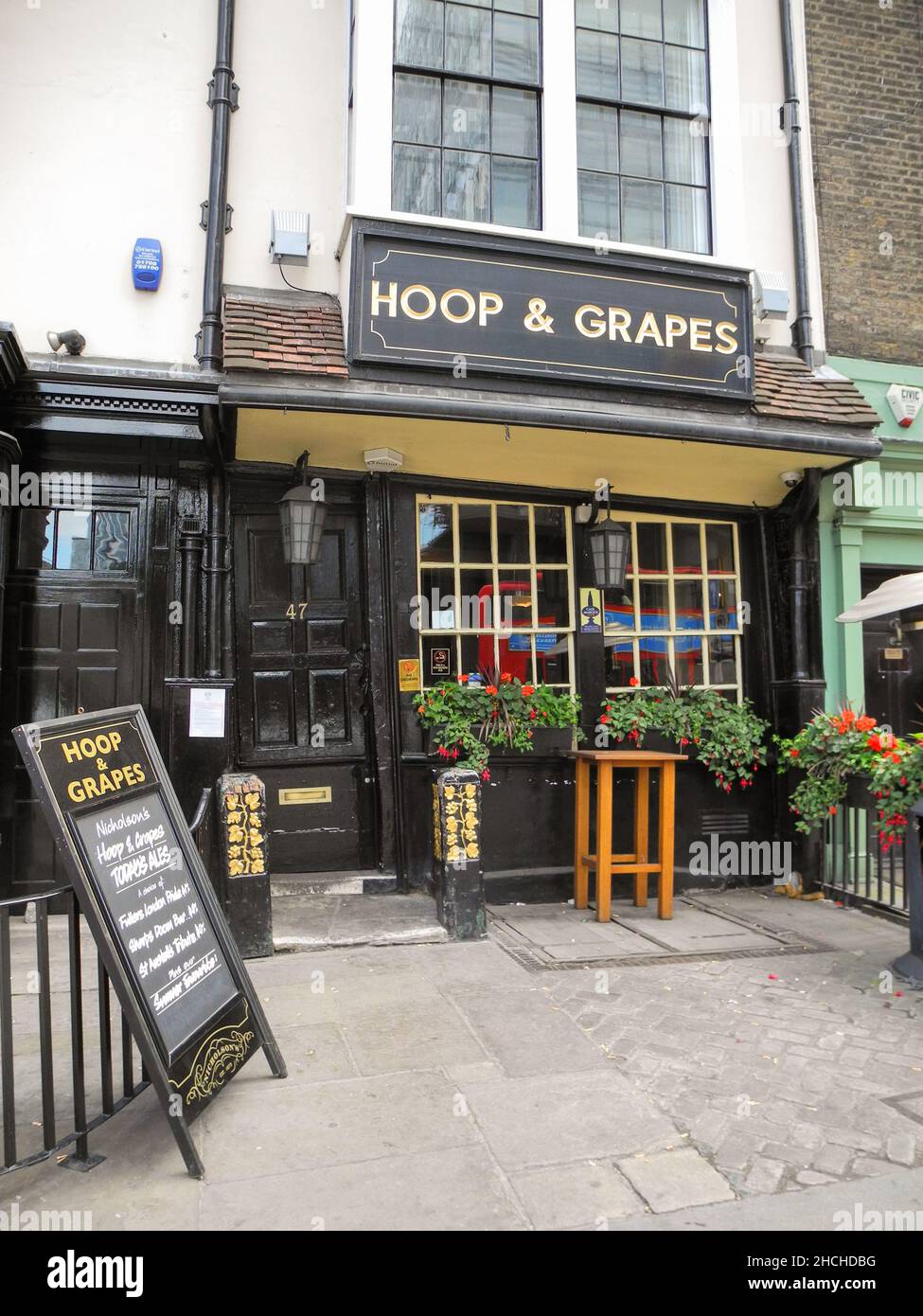 The Hoop and Grapes is a 17th century Grade II listed public house on Aldgate High Street in London's East End. Stock Photo