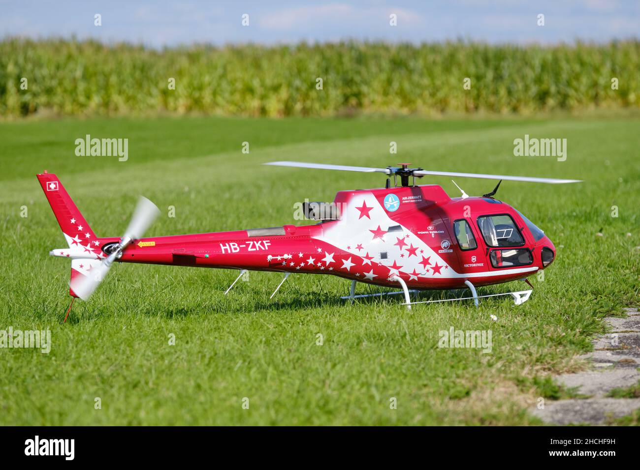 Neunhof, Germany - September 02, 2021: A radio controlled scale model of a AS350 Ecureuil helicopter with Air Zermatt design is standing on a meadow i Stock Photo