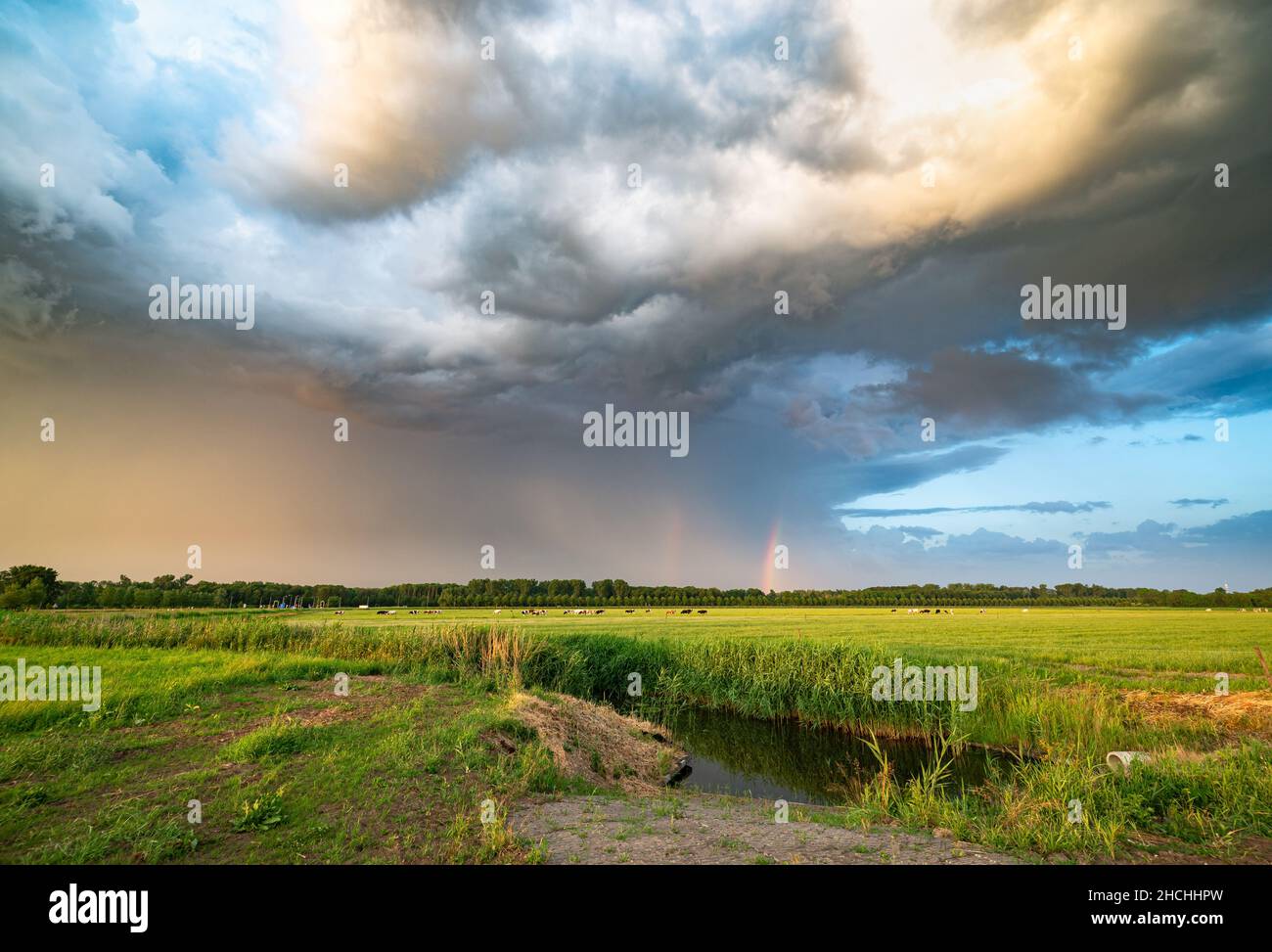 Rainbow with dramatic looking sky at the back of a severe thunderstorm over the Dutch plains Stock Photo
