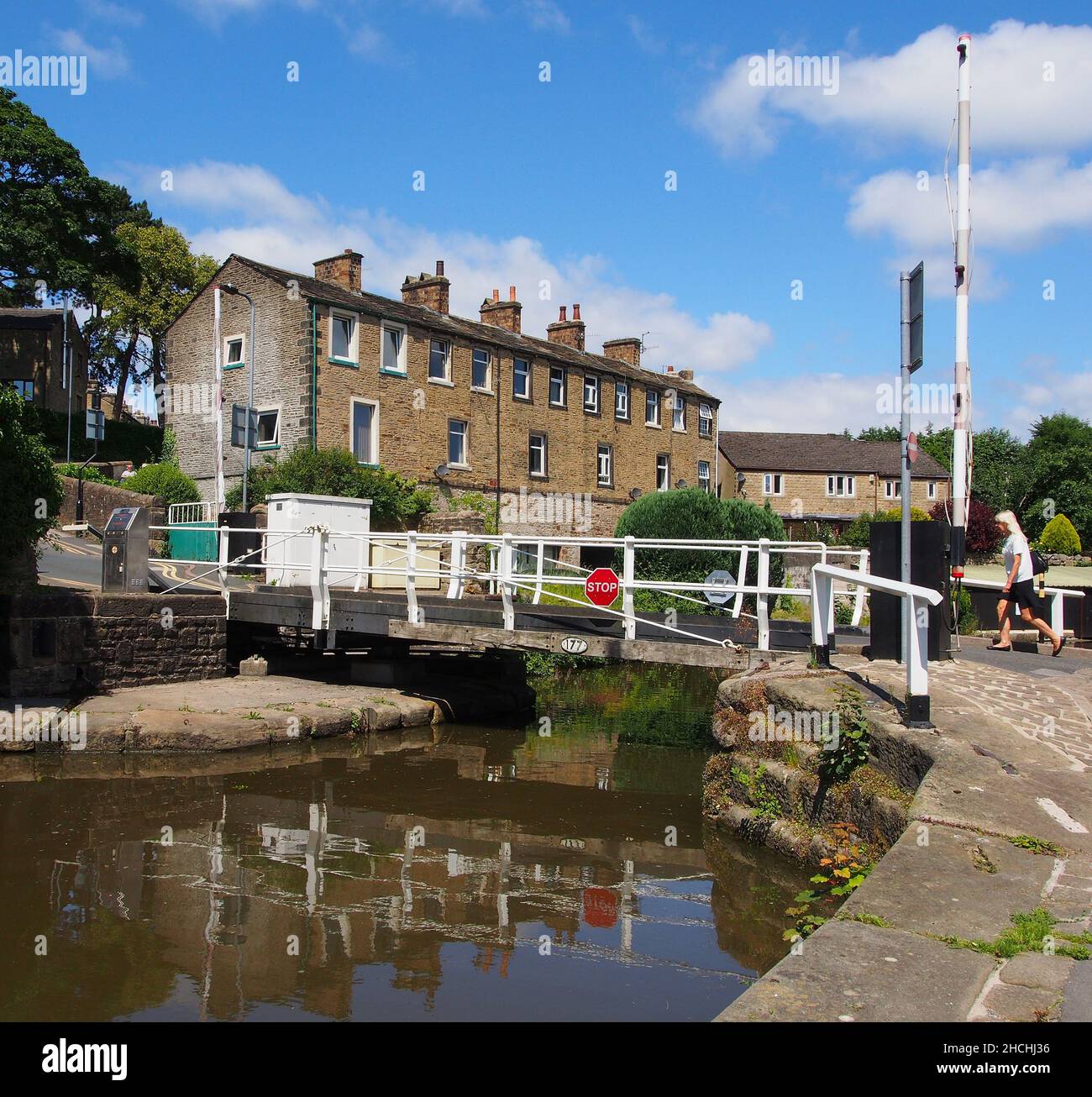 Swing bridge with a pedestrian about to cross on the Thanet Canal or Spring Branch of the Leeds and Liverpool canal from Skipton to Skipton Castle. Stock Photo