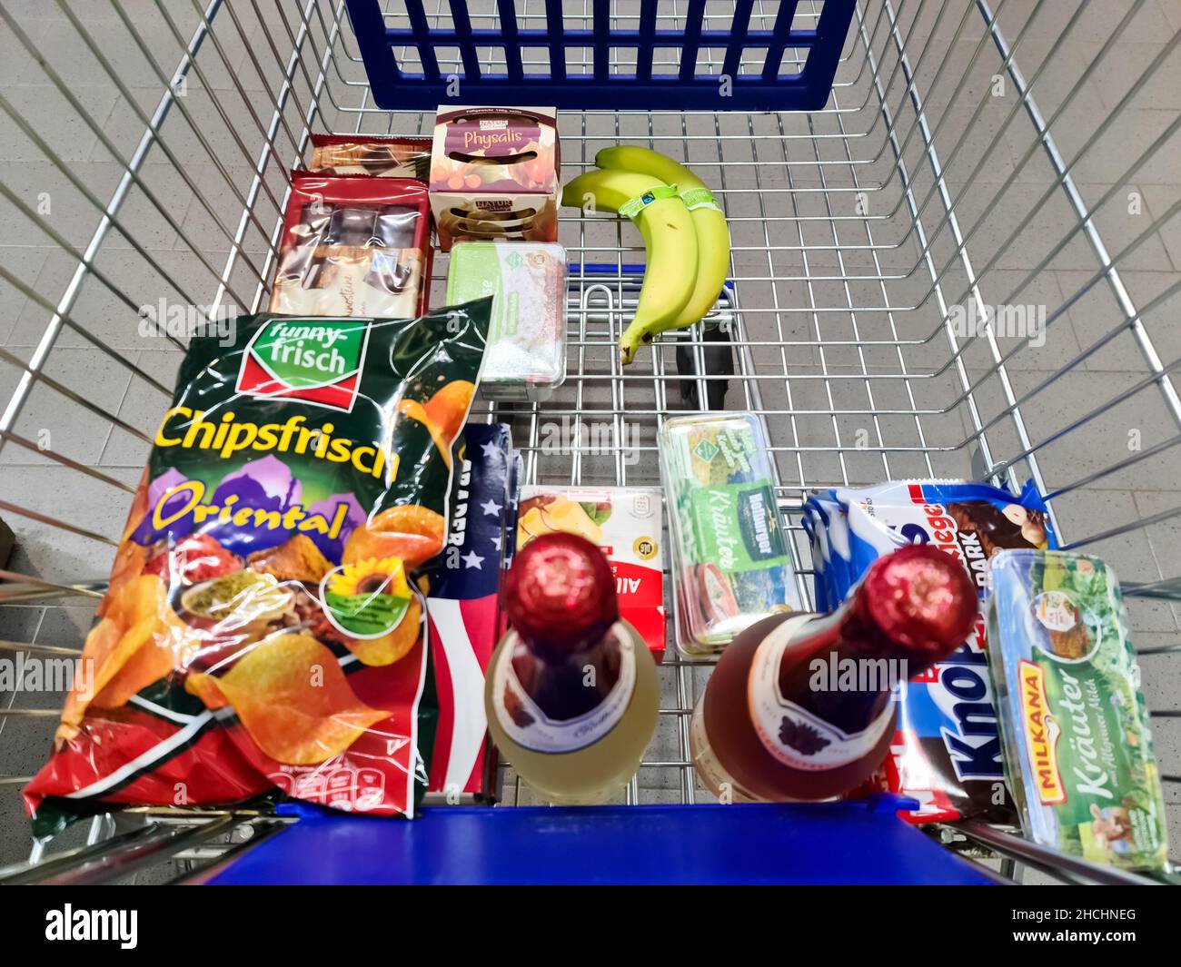Shopping cart with food like fruits, vegetables, and canned goods in an