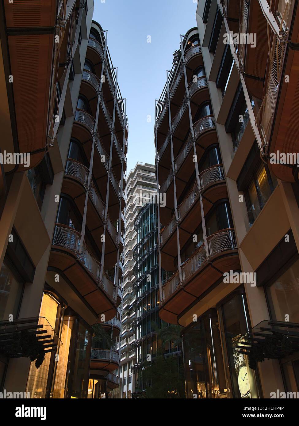 Low angle view of modern residential buildings in district Monte Carlo in Principality of Monaco at the French Riviera in the evening with shops. Stock Photo