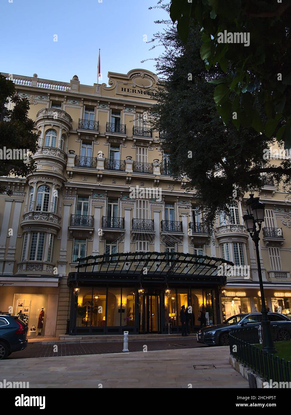 Front view of the entrance of historic luxury accommodation Hotel Hermitage in district Monte Carlo in the evening in Principality of Monaco. Stock Photo