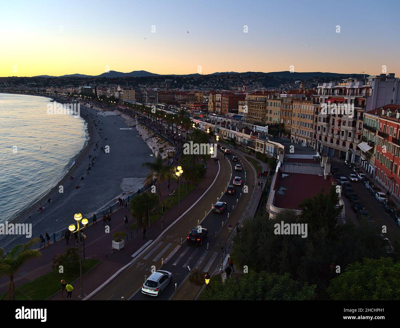 View of the downtown of Nice, France at the French Riviera with famous beach Plage des Ponchettes and Promenade des Anglais in the evening. Stock Photo