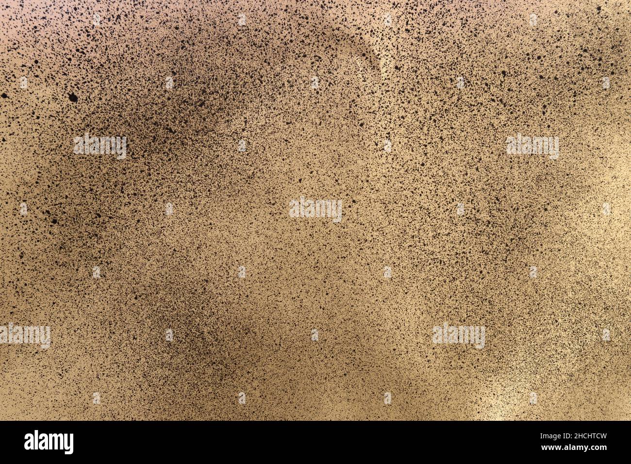 black spray paint on gold colored paper Stock Photo