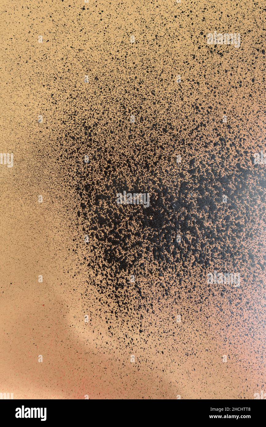 black spray paint on gold colored paper Stock Photo - Alamy