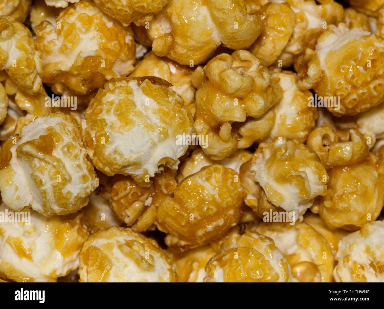 Caramel popcorn kernels up close with details and textures from directly above, selective focus