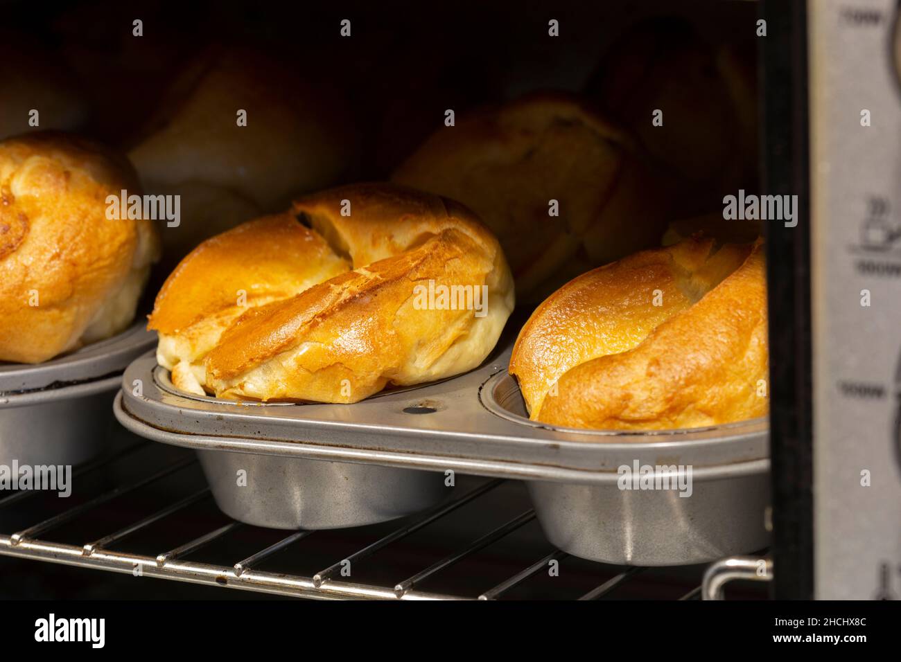 Individual Yorkshire puddings cooking in an electric oven. Traditional