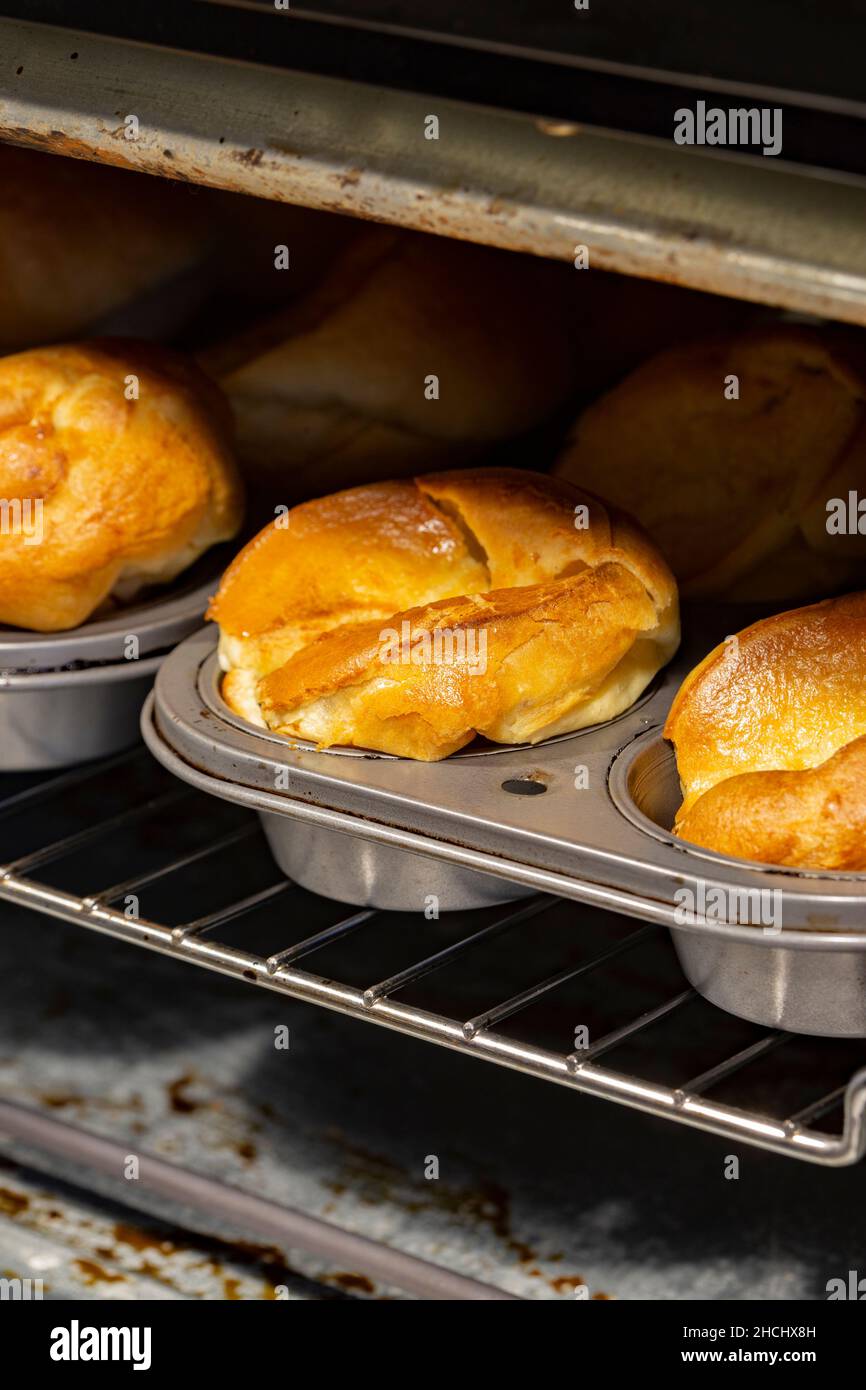 Individual Yorkshire puddings cooking in an electric oven. Traditional British food concept
