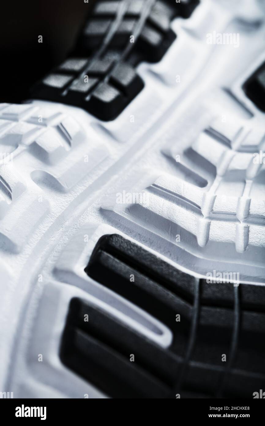 The black and white sole of trendy sports sneakers is a closeup in