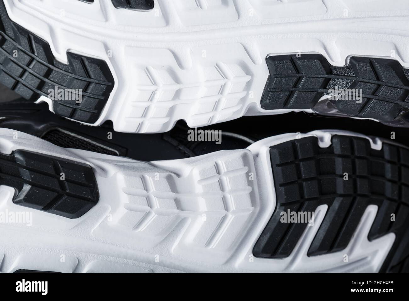 The black and white sole of trendy sports sneakers is a closeup in