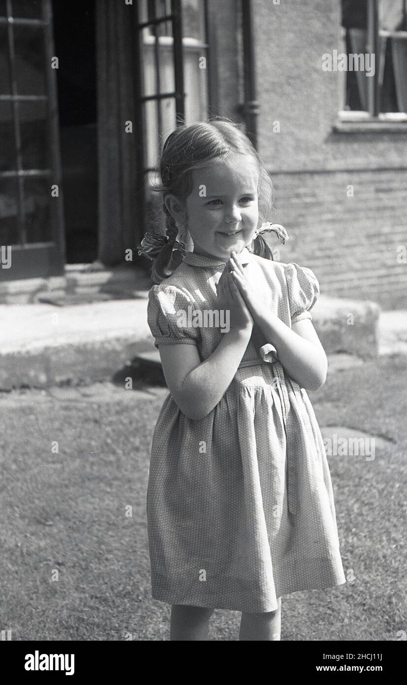 1960s, historical, outside in a garden, a sweet little girl in a summer