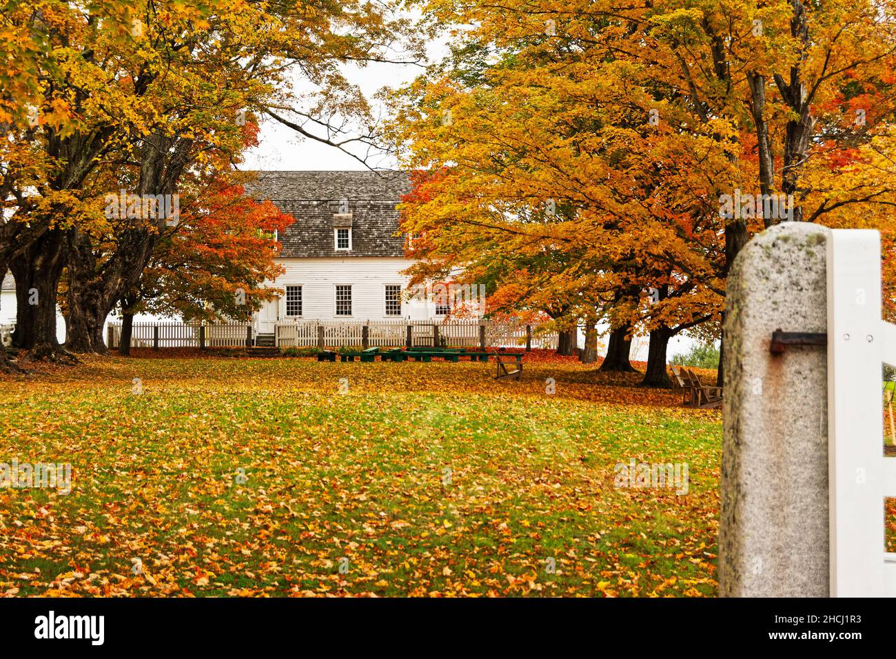 The meeting house sits in a field of fallen leaves. Canterbury Shaker Village, New Hampshire USA. Stock Photo