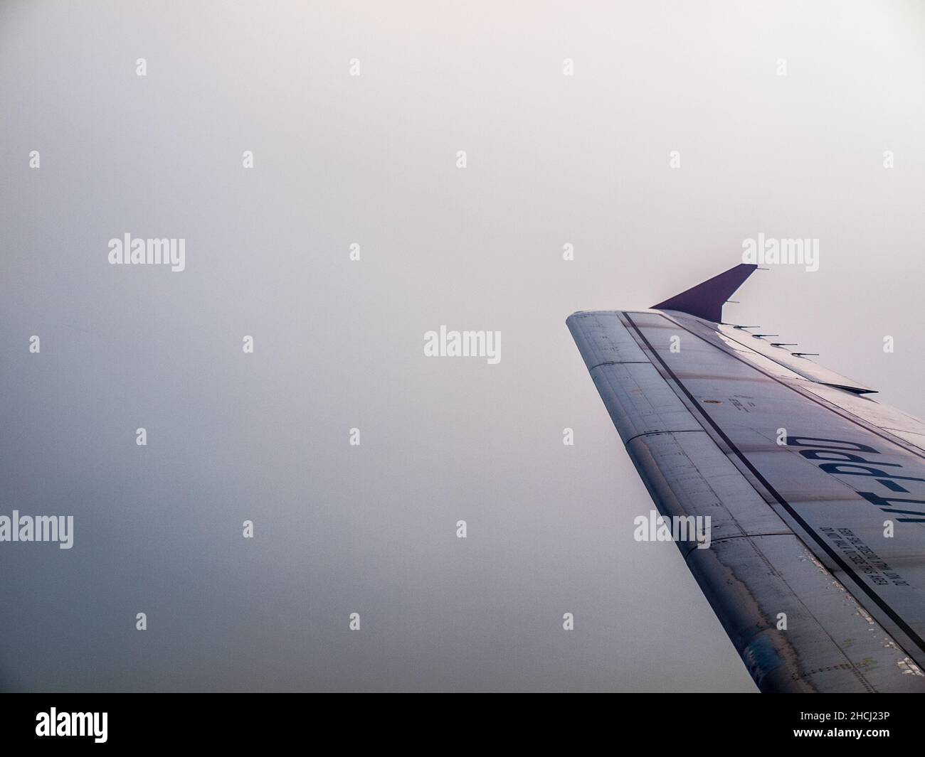 Airplane wing in white clouds background Stock Photo - Alamy