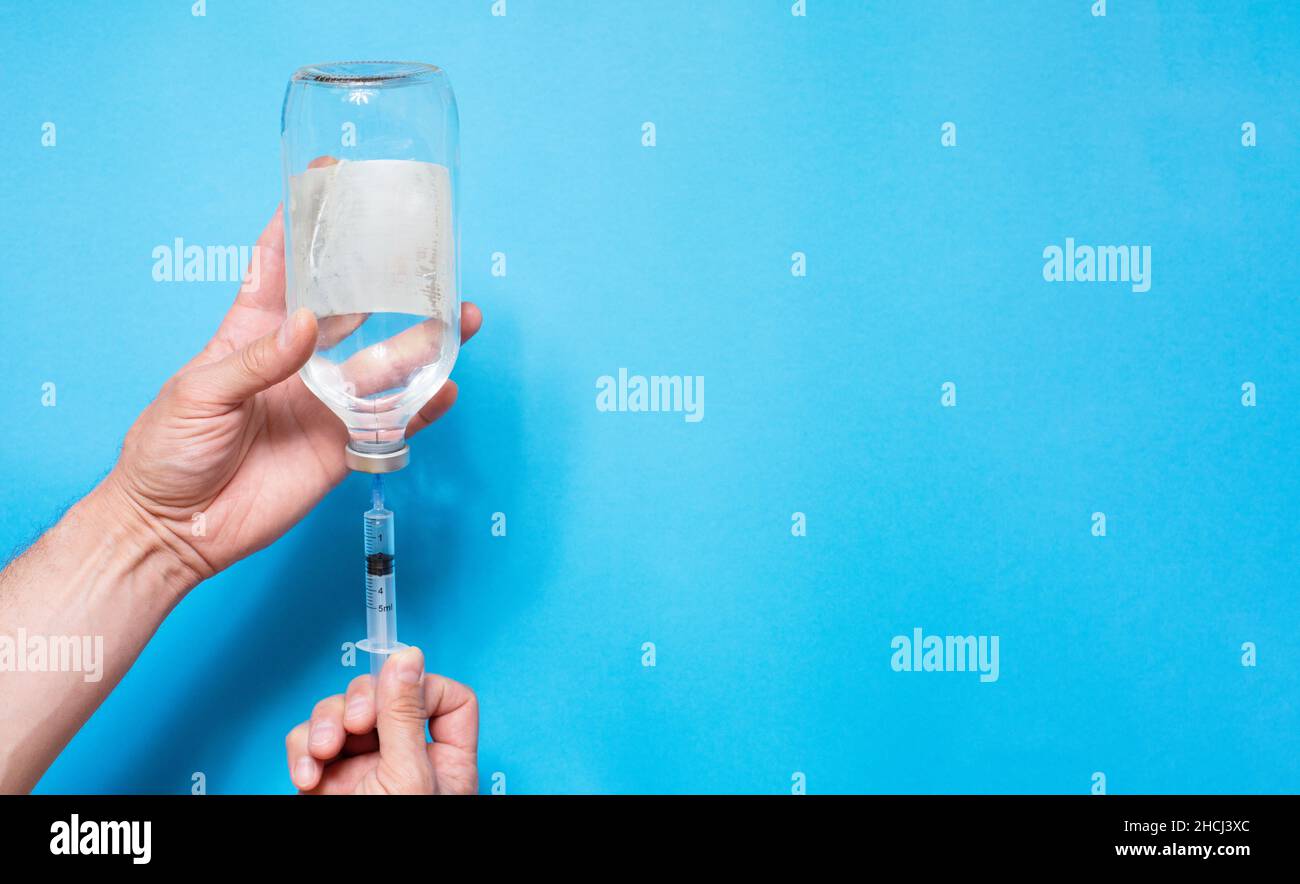 syringe with vaccine solution on the blue background Stock Photo - Alamy